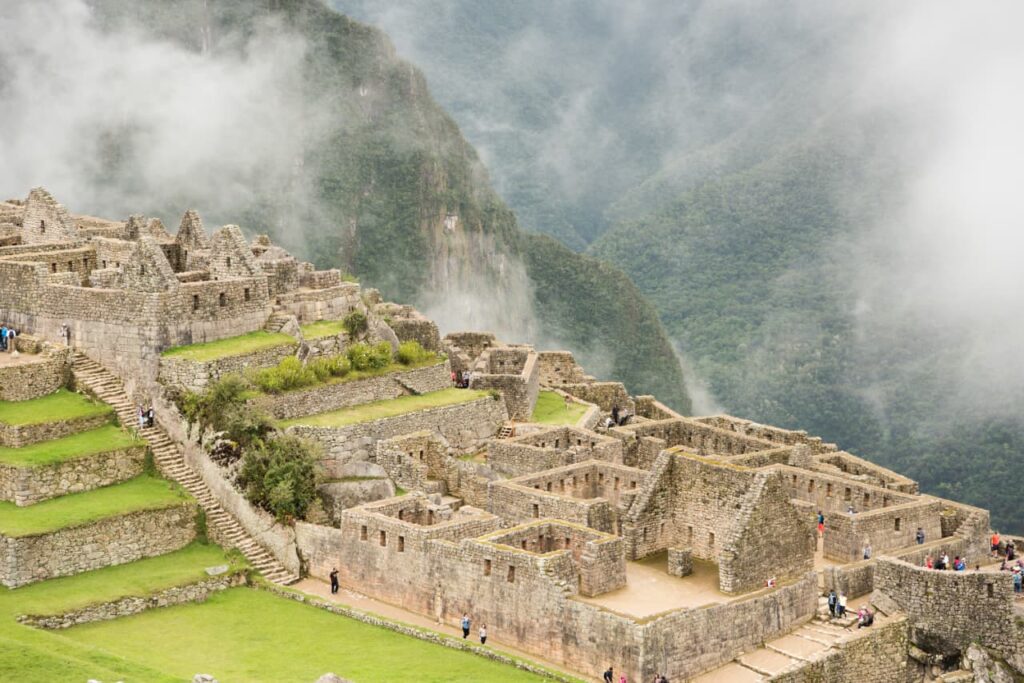 “Machu Picchu ancient Inca stone ruins with green terraces and misty Andes mountains”