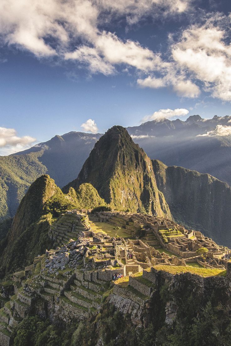 "Ancient Incan citadel Machu Picchu surrounded by Andes mountains under a bright sky"